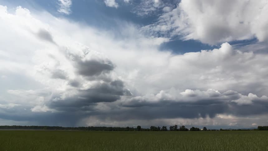 Green field with clouds passing by