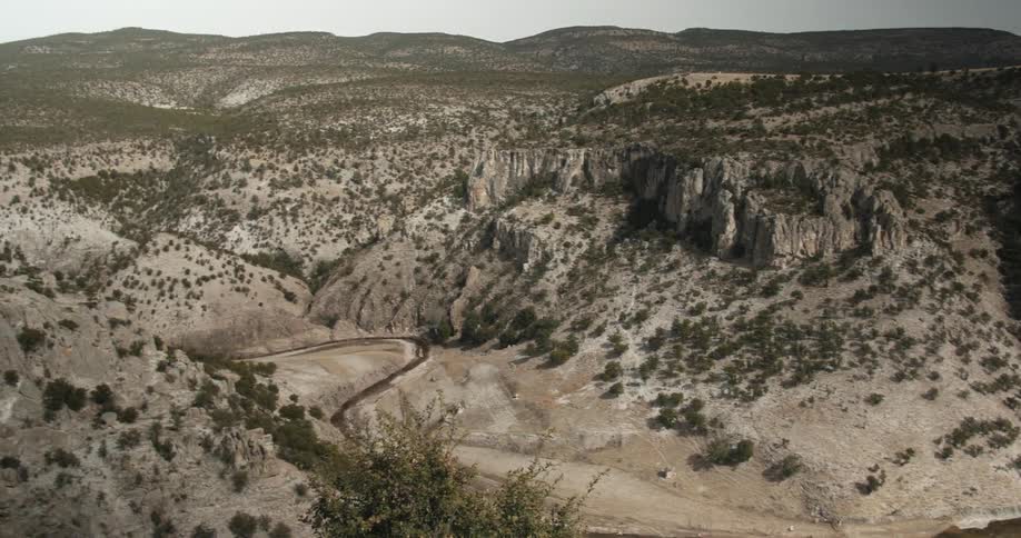 A river winds through a desert canyon during the day