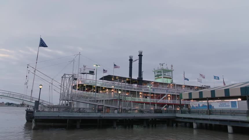 Flags blow in the breeze on a steamboat docked at pier