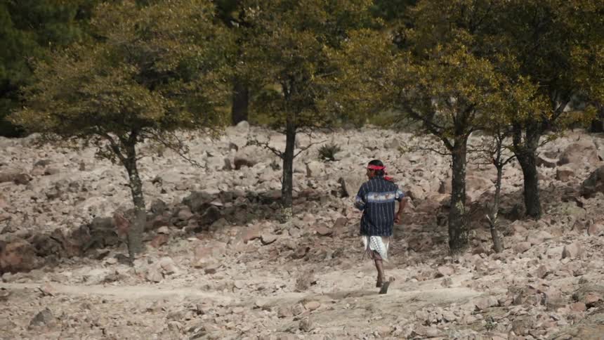 A man runs through a dirt area
