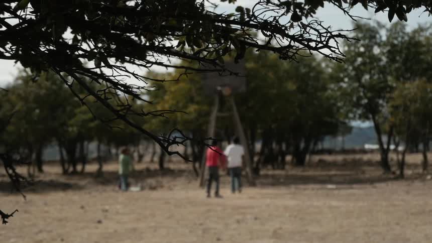 Boys playing basketball with a makeshift basketball hoop