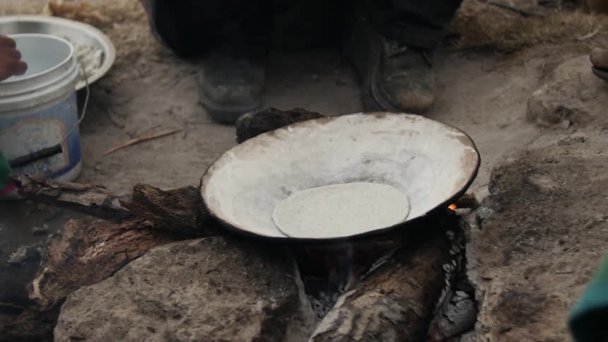 Woman  cooking tortillas that she has freshly handmade