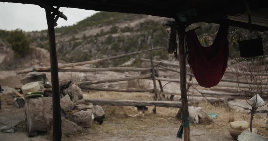 A view of a dilapidated wood fence with lots of large rocks nearby