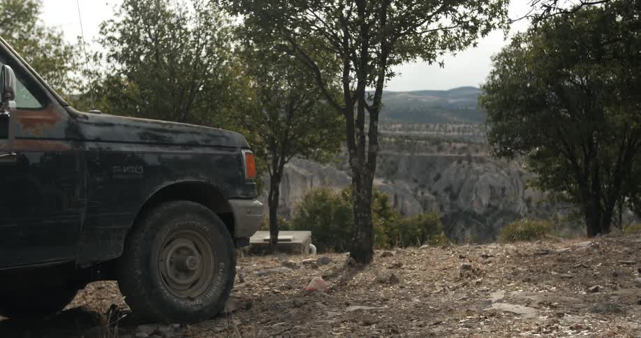 A truck is parked on a hilltop on a cloudy day