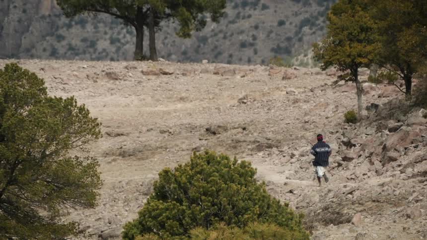 A man is running down a dirt trail