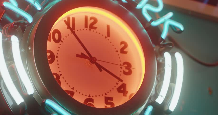 A neon clock counts the time inside a building