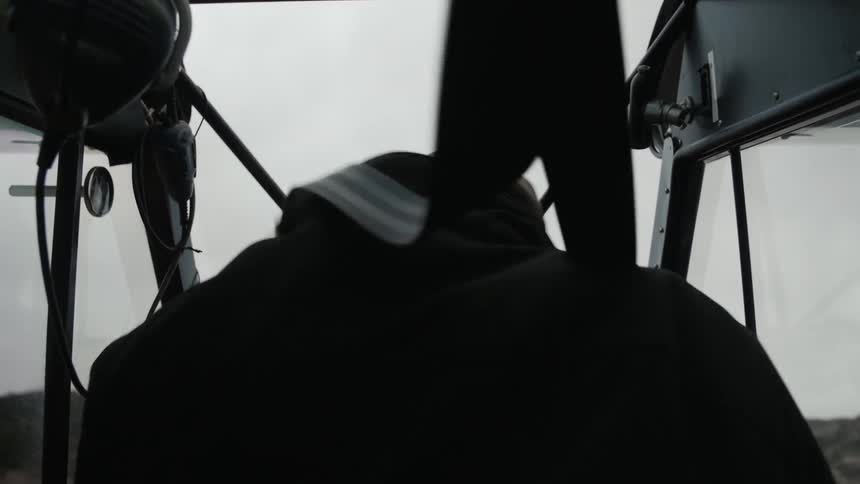 Man in a baseball cap securing himself in with attached straps