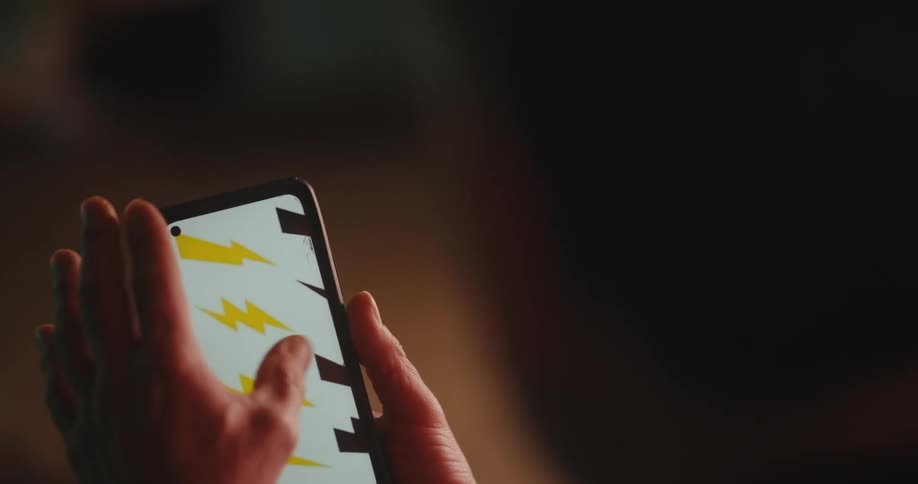 Man using his cell phone to choose a lightning shape for a neon light