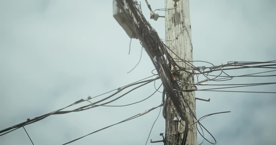 A utility pole full of wires in the city