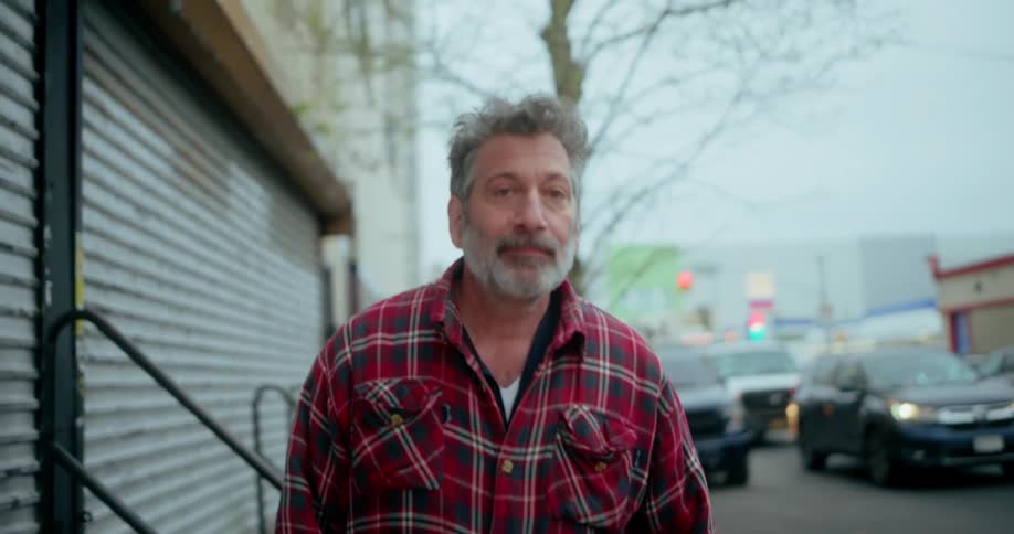 A man is walking down the sidewalk