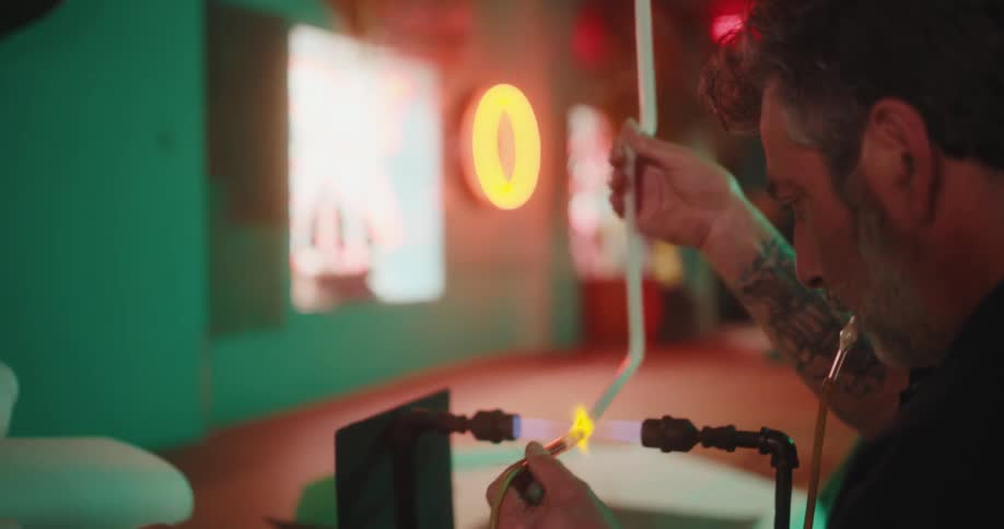 A worker heats a tube over a flame