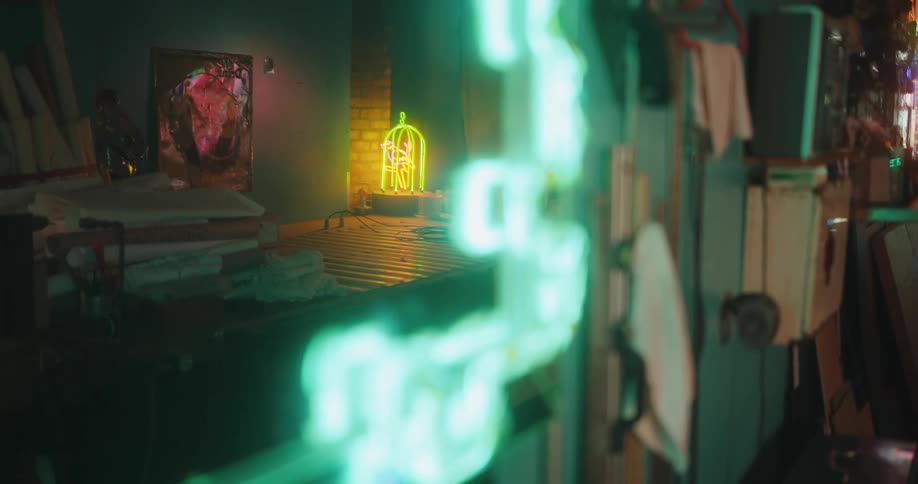 A mirror on the wall reflecting a bright yellow neon object on a table
