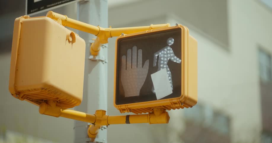 A crosswalk signal changes from red to white