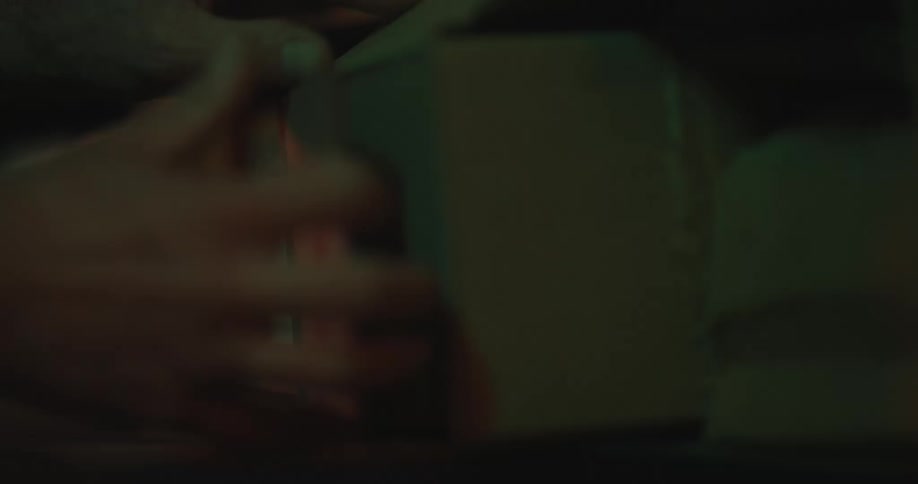 A man opens a box that is sitting on a shelf
