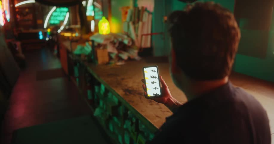 A man is checking his cell phone in the shop