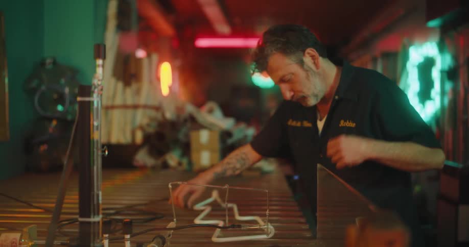 Concentrated man working on a board with lightning symbol on the table