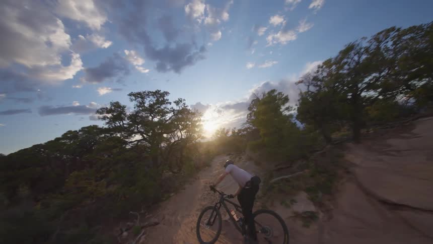 A man is mountain biking past the cliff