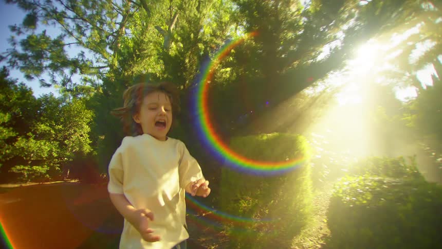 Smiling boy running in a garden