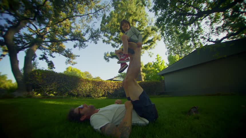 A father is playing with his son in the yard