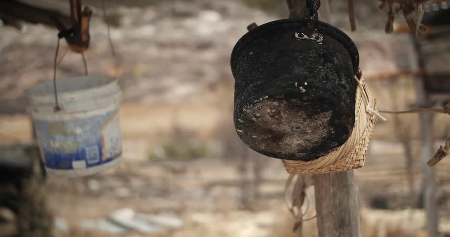 A couple of dirty looking buckets hang from wood posts