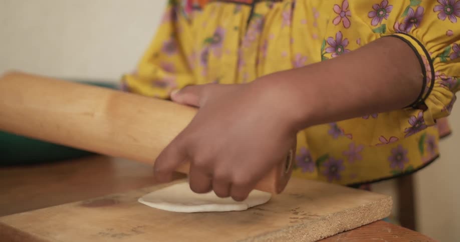 Woman rolling dough with a large rolling pin