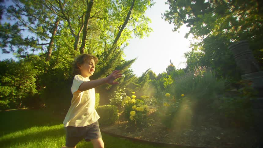 A boy running across a garden