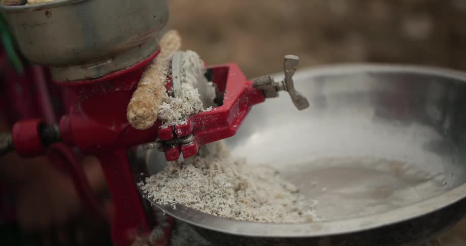 A machine is grinding something into a bowl