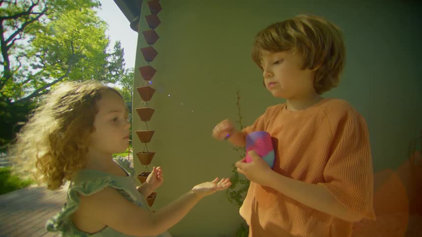 Two children are eating outside