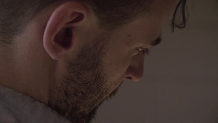 A man is indoors looking down at something