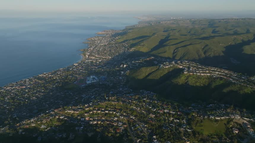 One view was of a large coastal city with several houses and some of them on top of a green hill