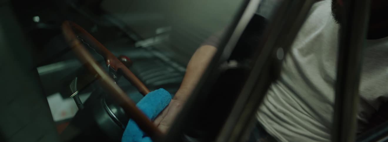 A man cleans and polishes the vehicles steering wheel