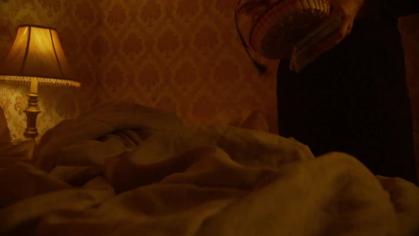 Two people inside a dimly lit room holding objects