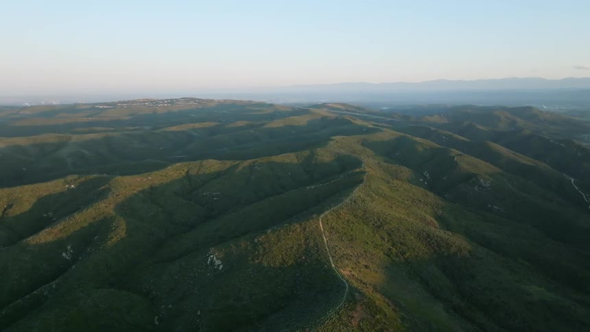 A road runs over the top of a mountain in a rural area