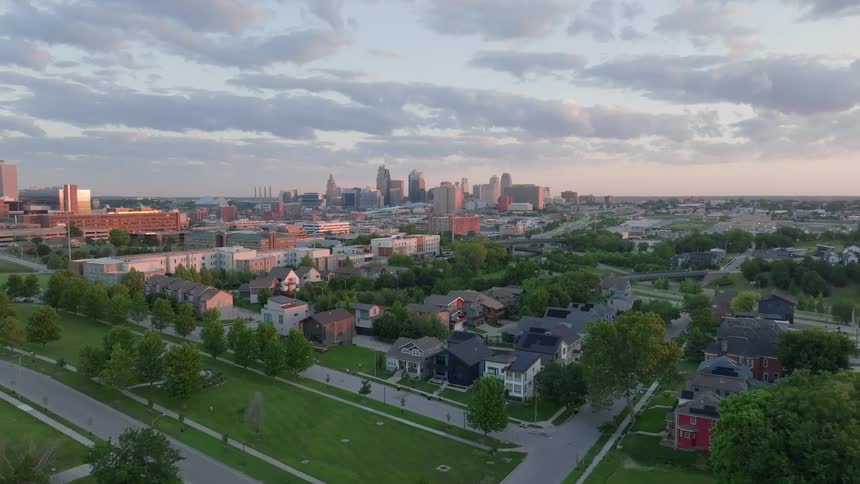 Aerial scenery of a residential neighborhood with large buildings on the horizon against a cloudy sky
