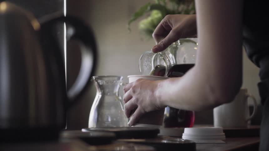Person pouring coffee into a cup