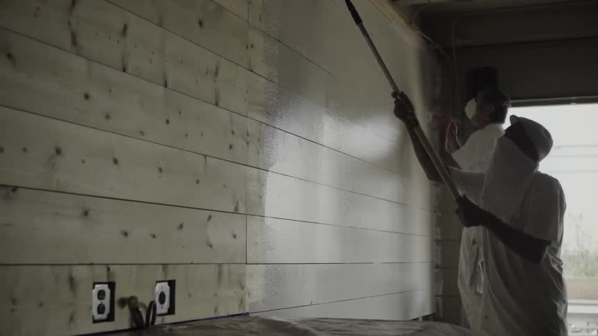Workers painting in the interior of a building during the day
