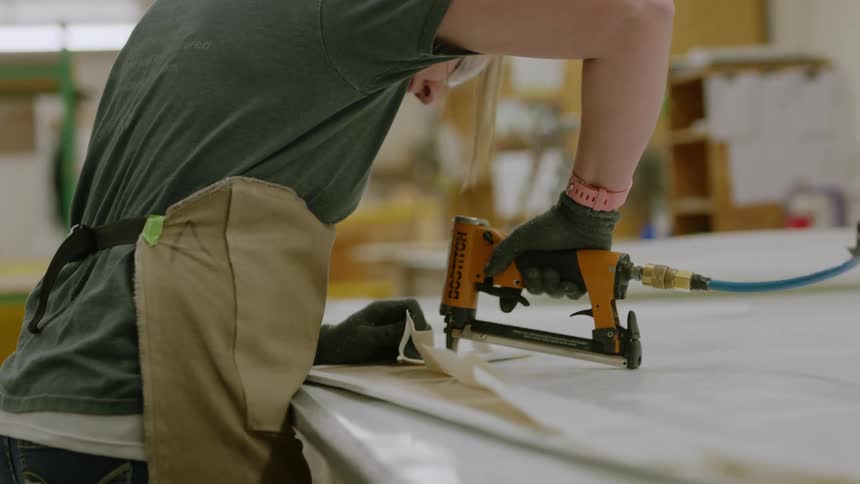 Woman using a pneumatic nail tool in a manufacturing process
