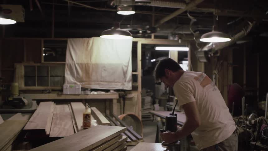 A man sanding wood with a power sander