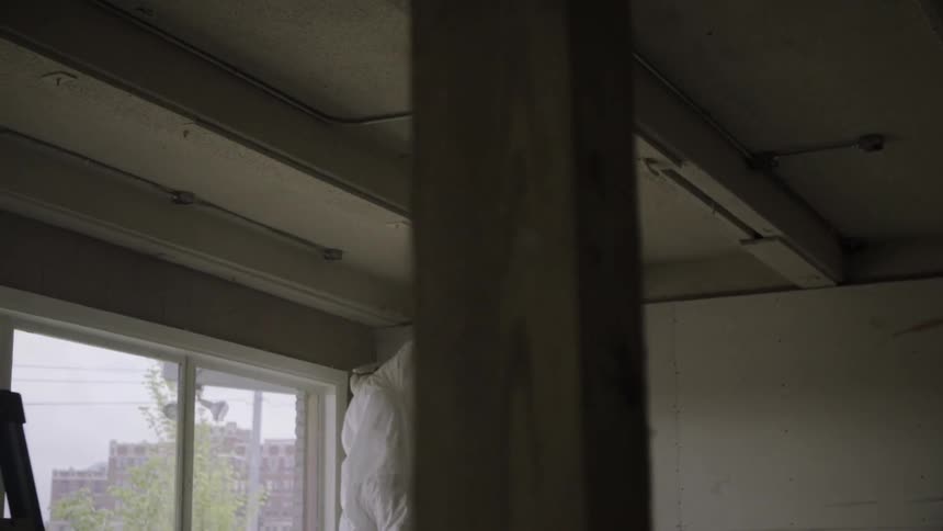 Person spray painting ceiling inside building