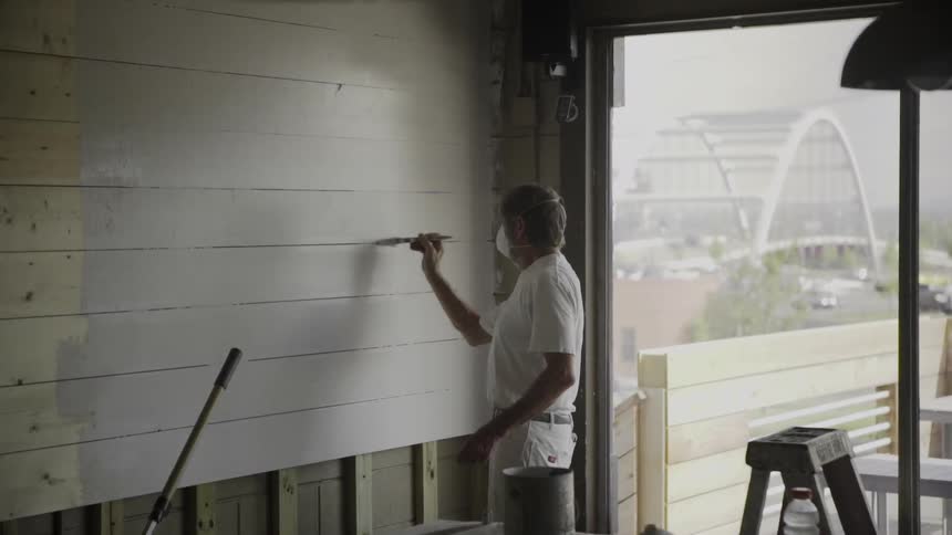 Man painting a wall in a building