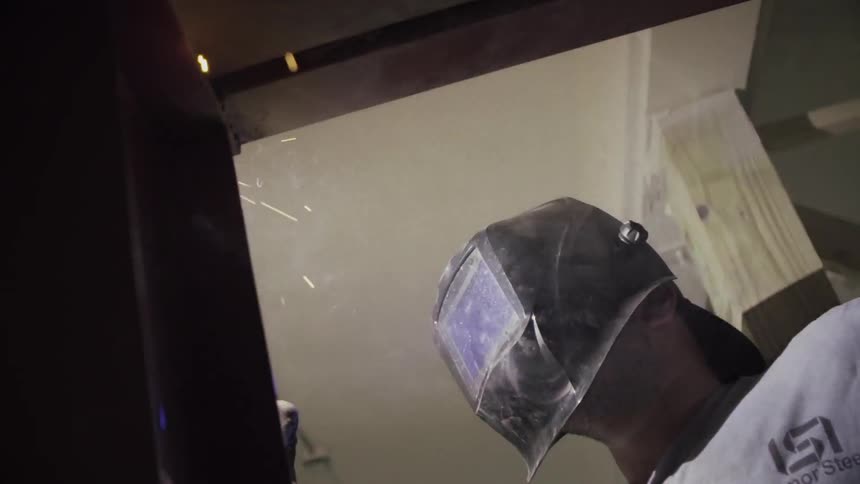 A man is welding inside of a room