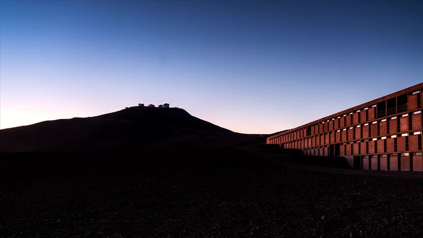 Antenna arrays set in an arid landscape under a dusk sky