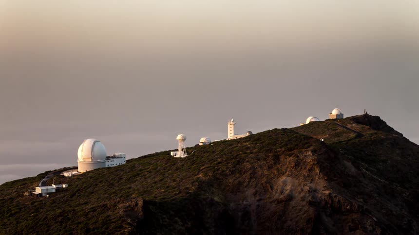 Antennas and observatories on a mountain peak as the day approaches dusk