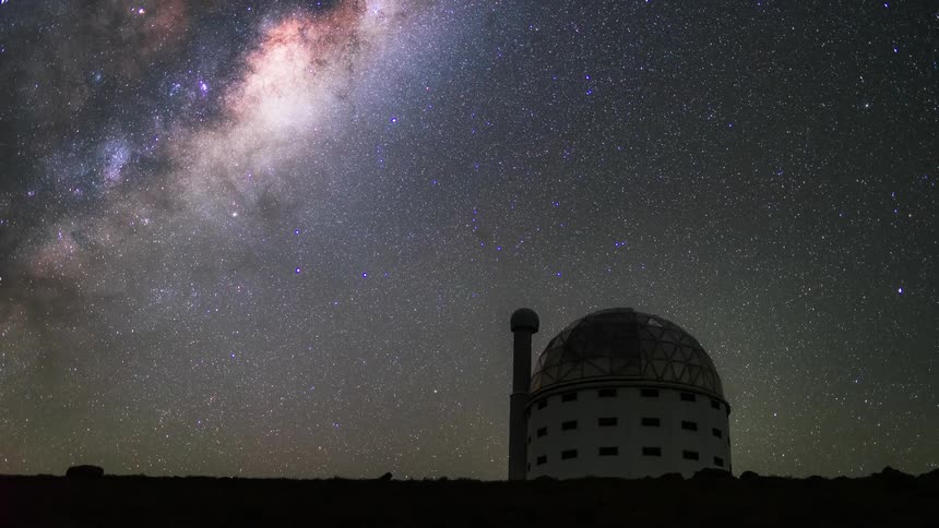 An observatory facing the sky and the sky is all stars and with a bright mist and it is dawn