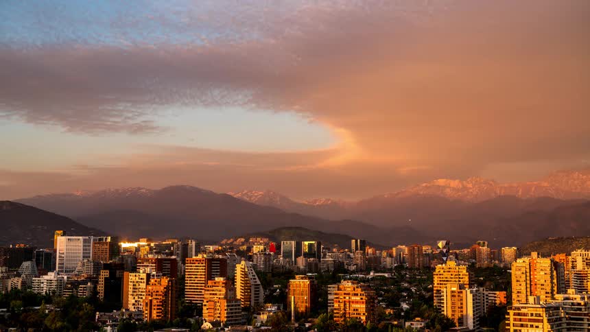 Late afternoon panorama with the sky turning purple above a metropolis surrounded by mountains