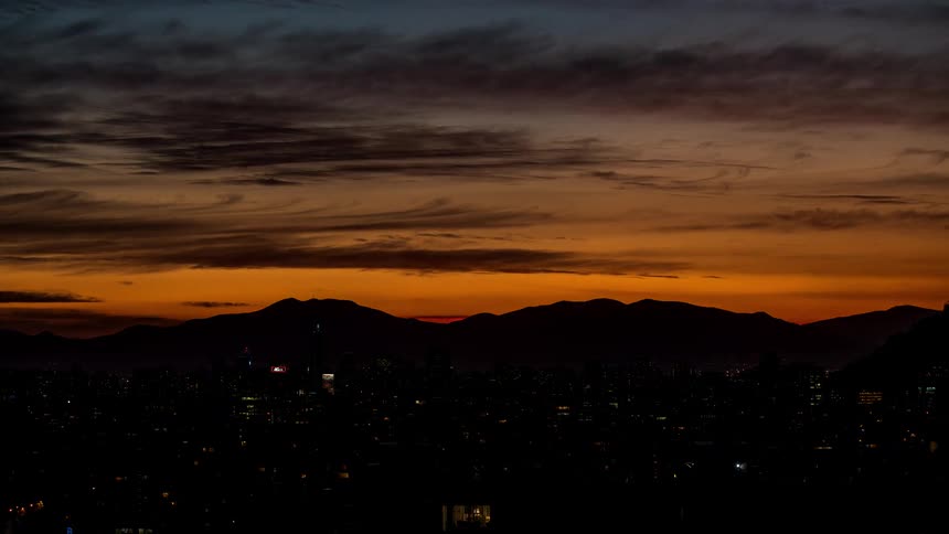 A city lights up at night as the day gives way to night
