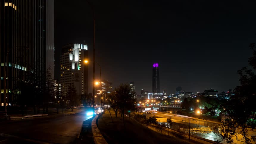 Traffic passes by the buildings at night