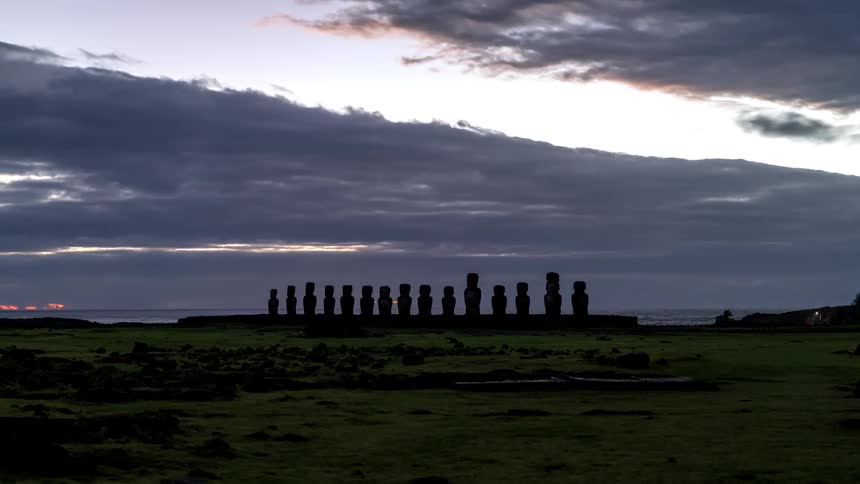 Row of moai statues during sunrise