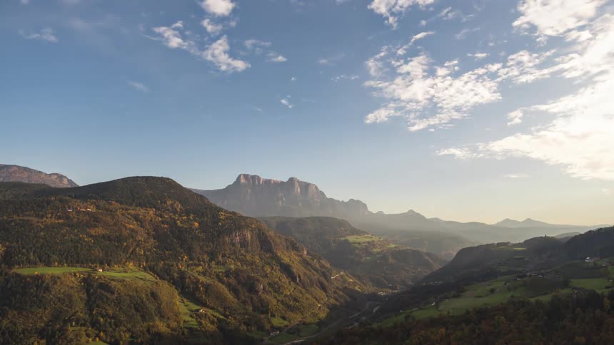 Mountains contain small rural type communities as planes fly overhead from midday to night