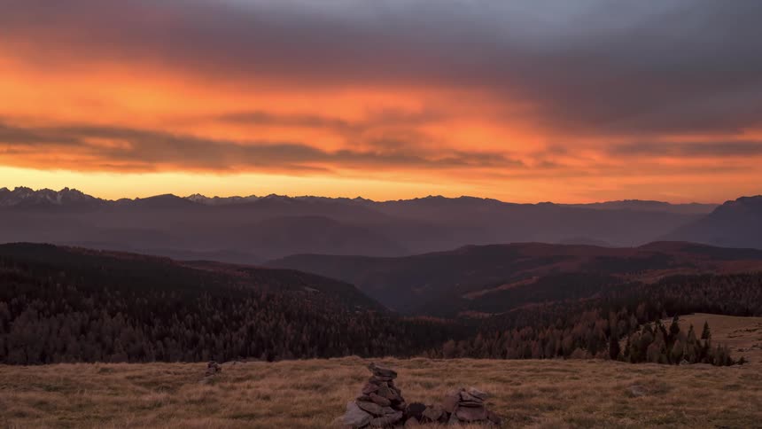 Landscape with red sky dawning over mountains with vegetation